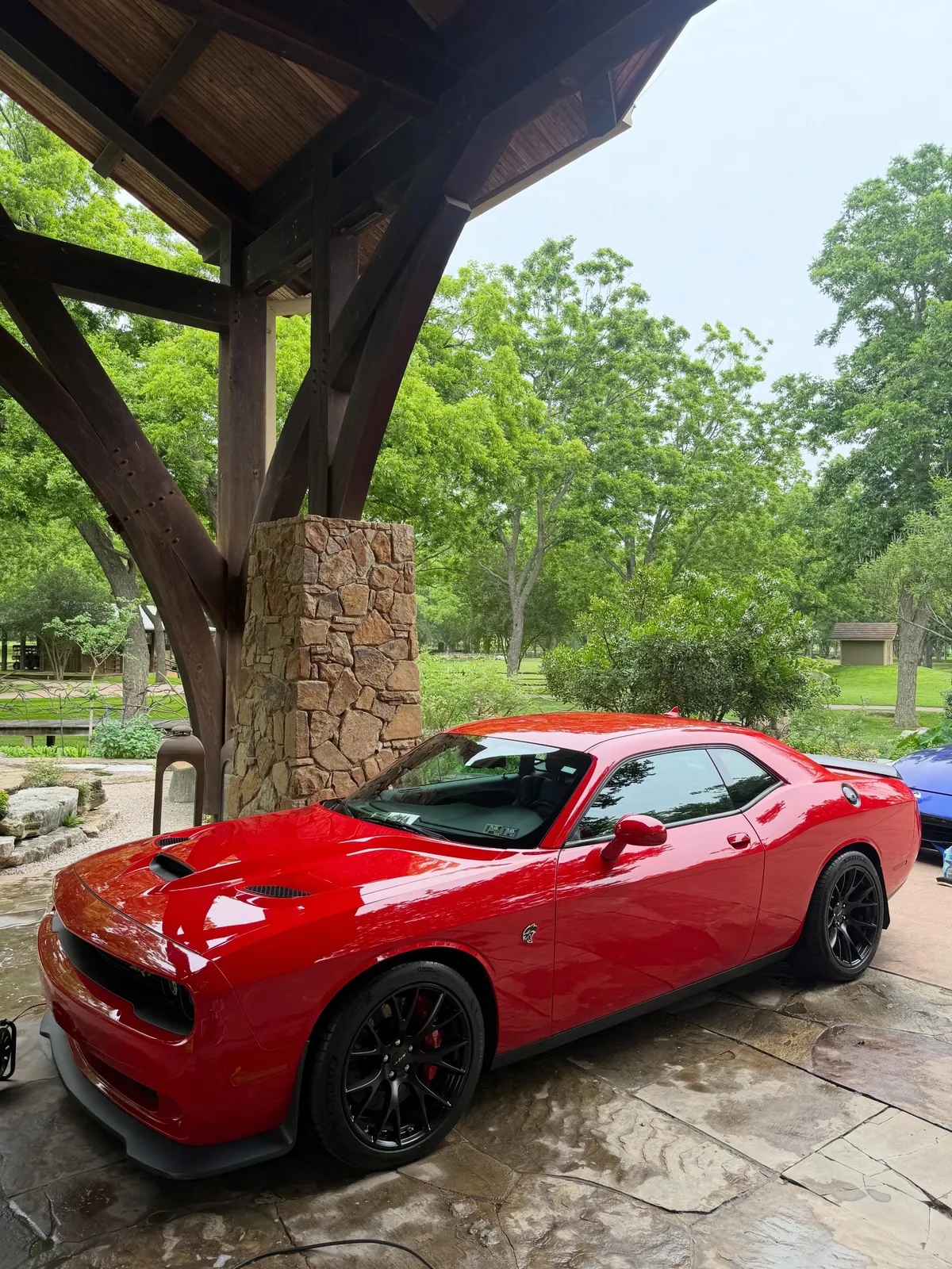 Red Dodge Challenger detailed under a timber pavilion